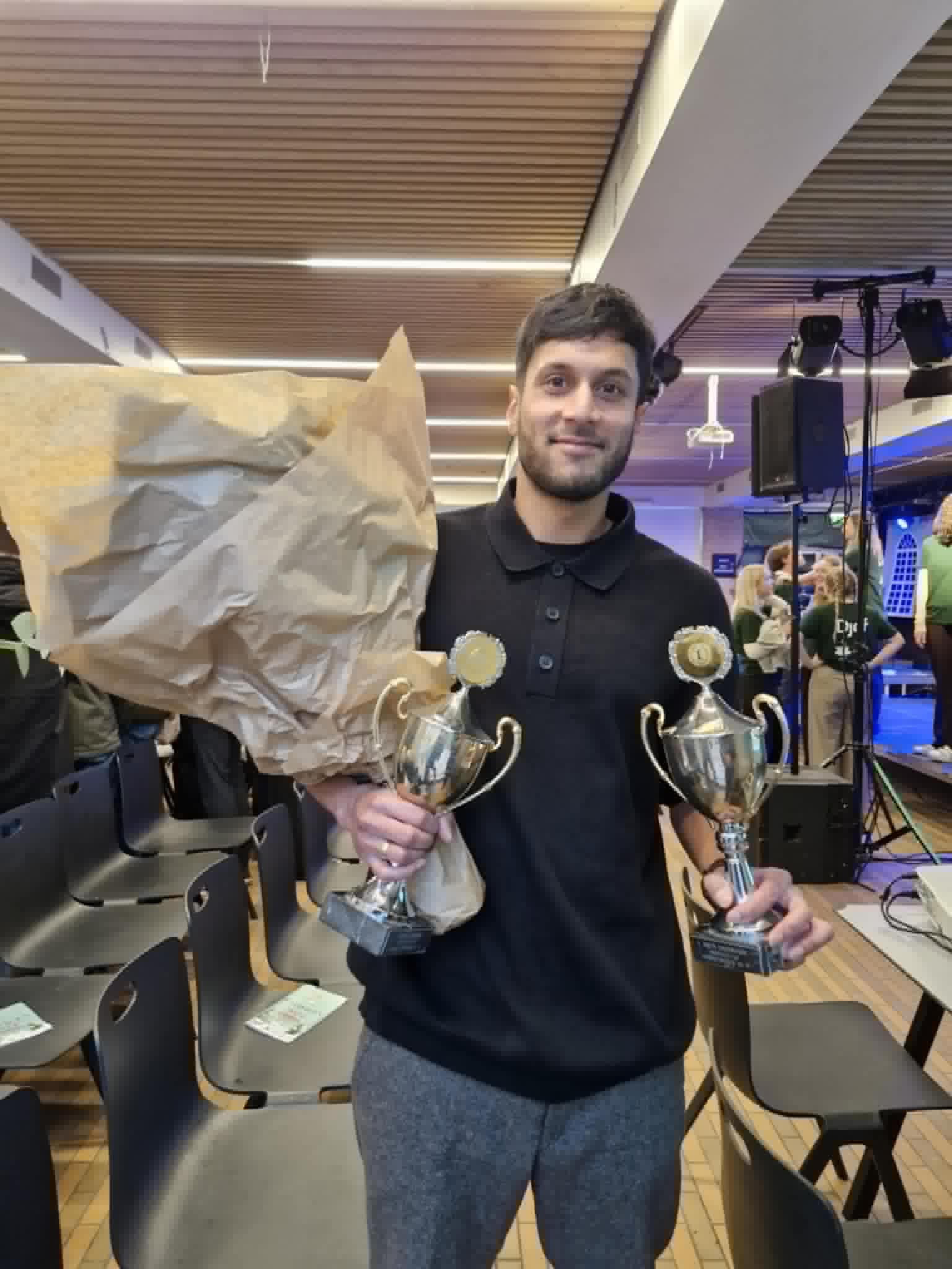 Person in a room, prizes, flowers, smile, 