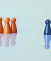 A group of orange playing pieces and a single blue onen enkelt blå brik