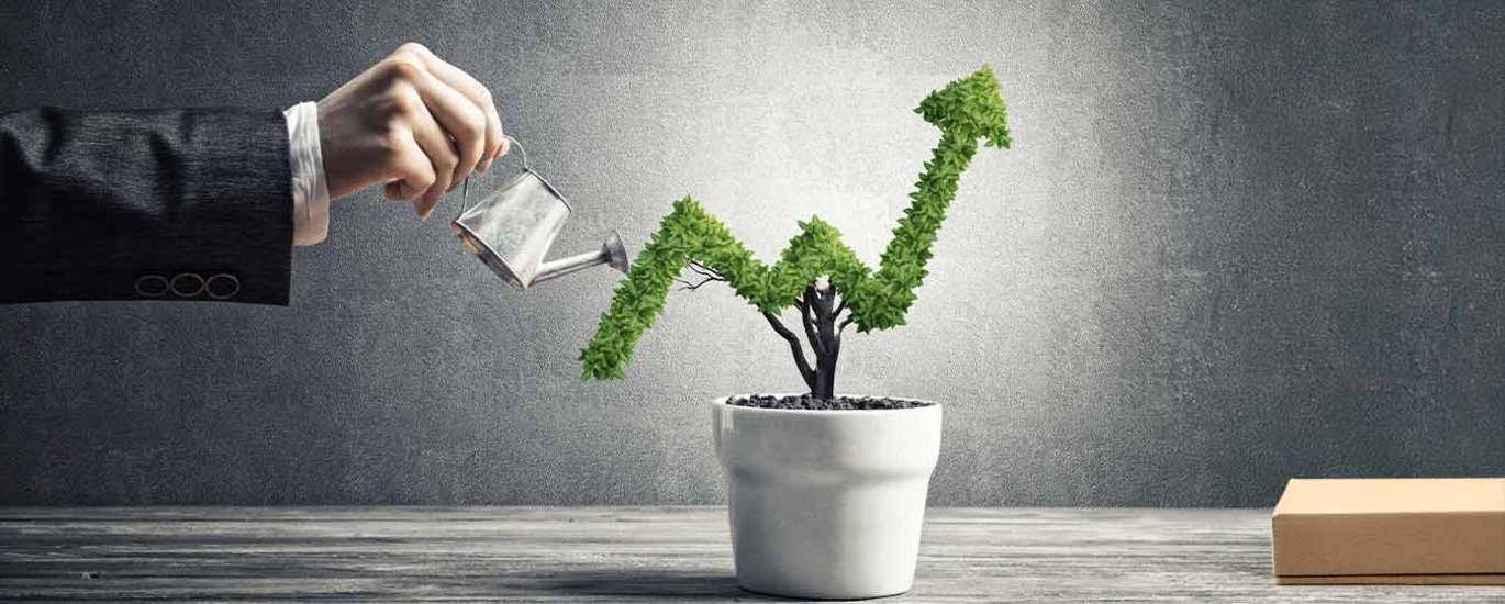 Man waters plant with the shape of an upward share price